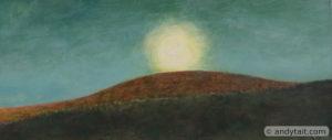 Sun sinking behind hill